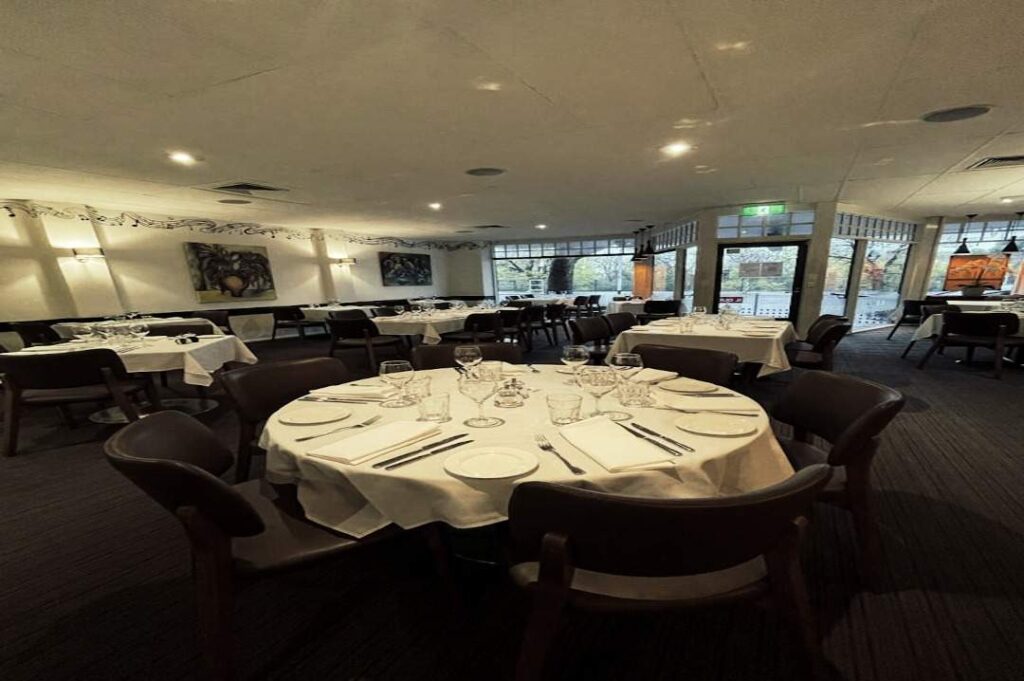 Elegant dining room of Il Duca Italian Restaurant in East Melbourne, set with round tables, white linen, and glassware, showcasing a warm and welcoming atmosphere near the MCG and Melbourne’s sports precinct.